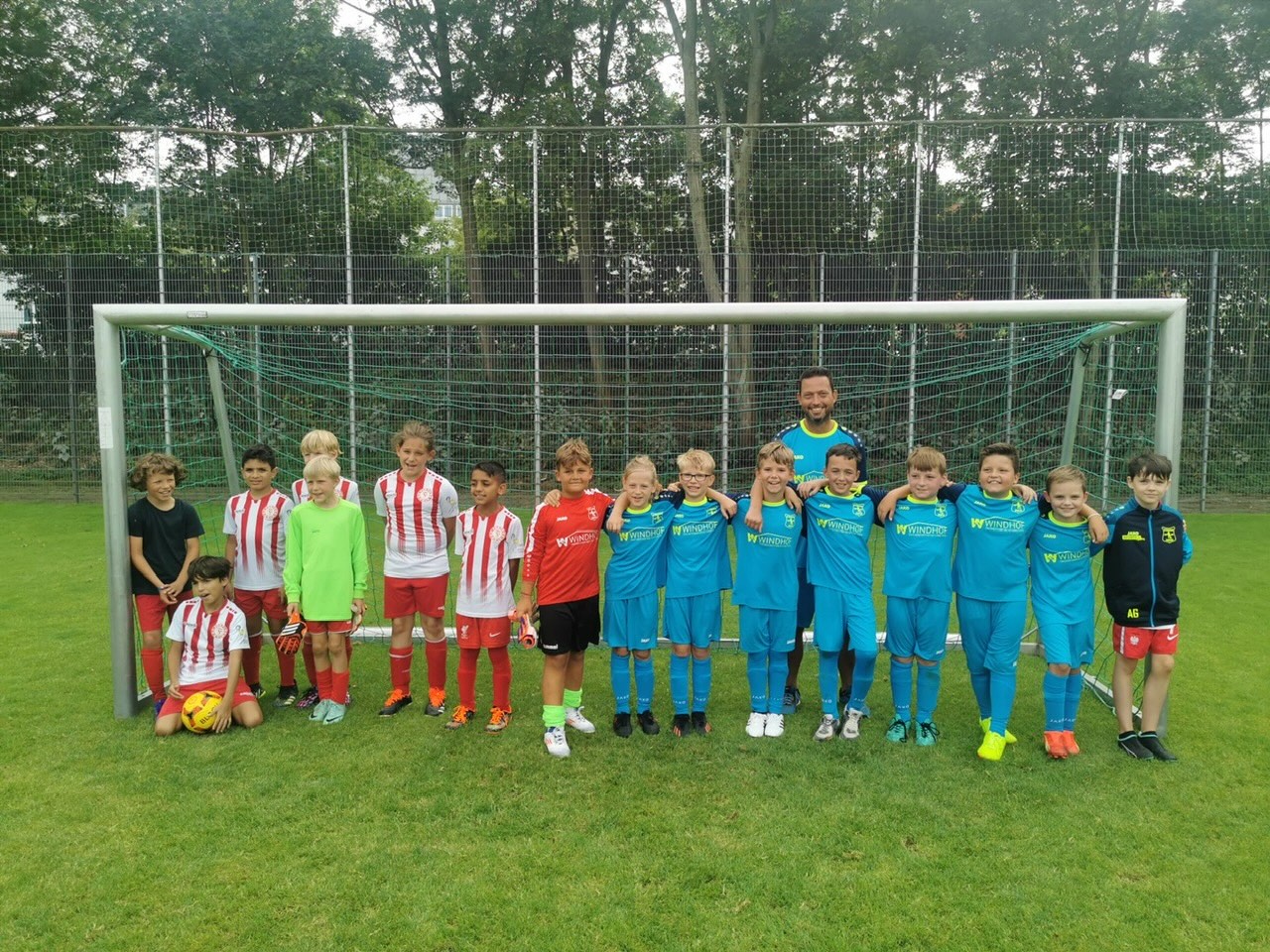 Mannschaftsfoto der U10/2 beim SV Frömmersbach: Kinder in blau-roten Trikots und ein Trainer vor dem Tor gegen Fortuna Köln